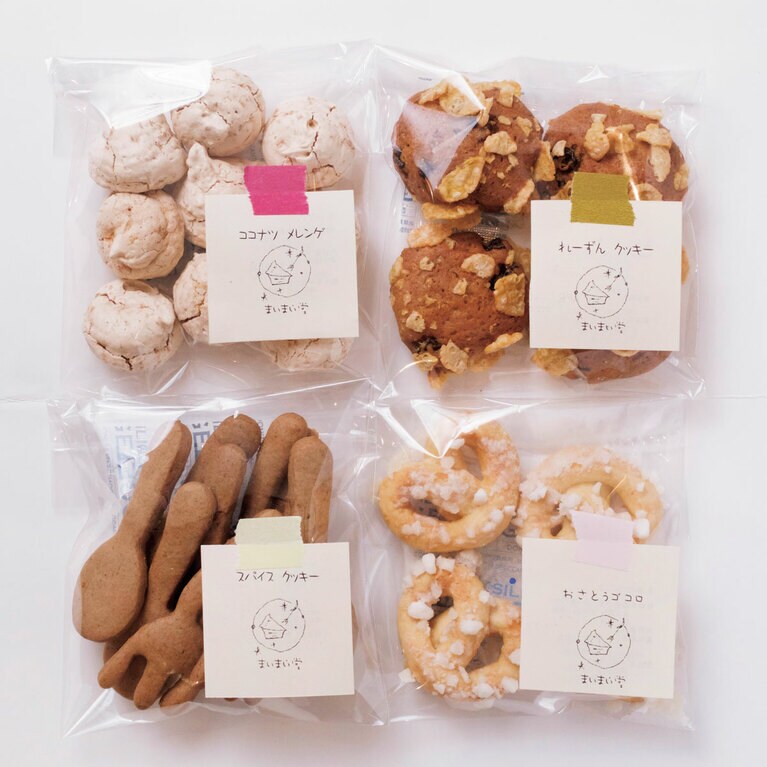 ガラスのショーケースに並ぶ手作りクッキー。「れーずんクッキー」「おさとうゴコロ」「ココナツメレンゲ」「スパイスクッキー」すべて270円（イートインは275円）。