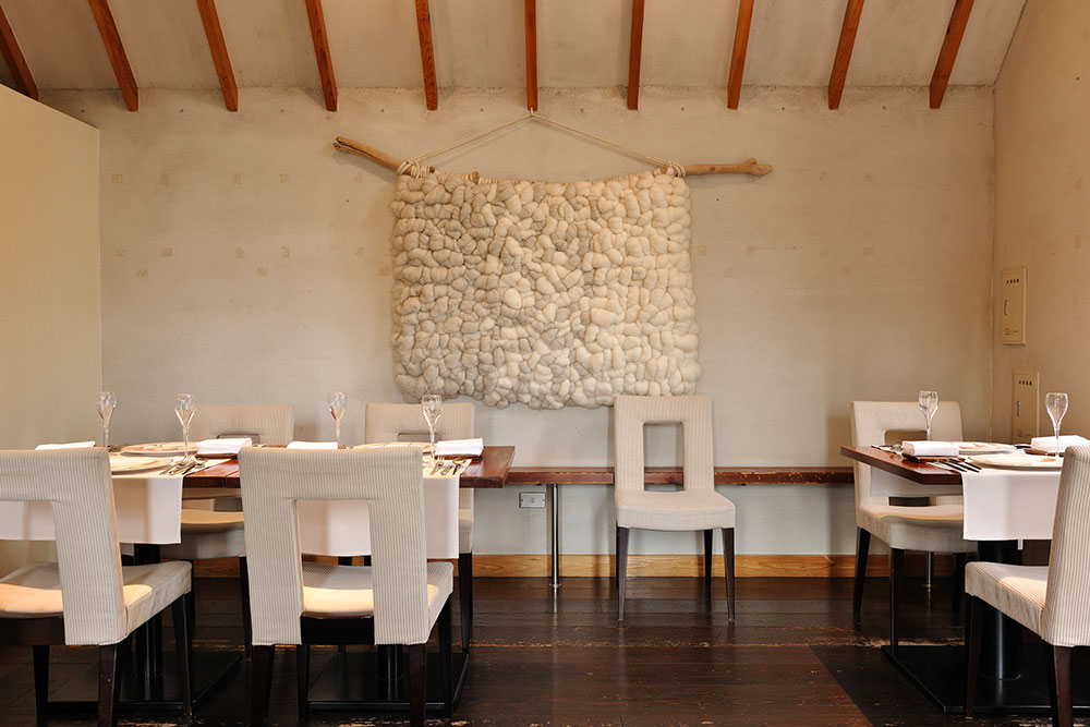 壁にはneulo熊谷美沙子さんのタペストリー。天井の高い一軒家で開放的だ。