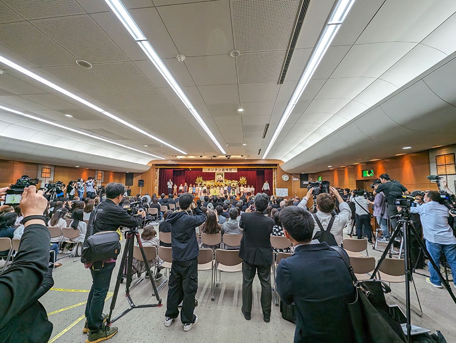 追悼式でタンタンに向けて歌う青谷愛児園の園児。客席の左右と後方で立っているのは報道関係者ら。