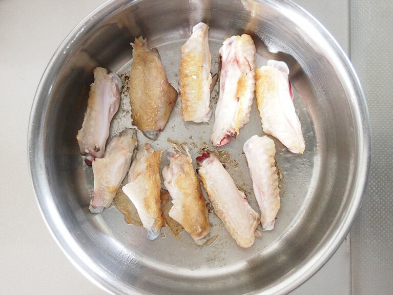 (2) 鍋を温めてオリーブオイルを敷いたら、塩胡椒を振った手羽中肉を入れて焼きます。表面にきつね色の焼き色がついたら、裏返して両面を焼きます。