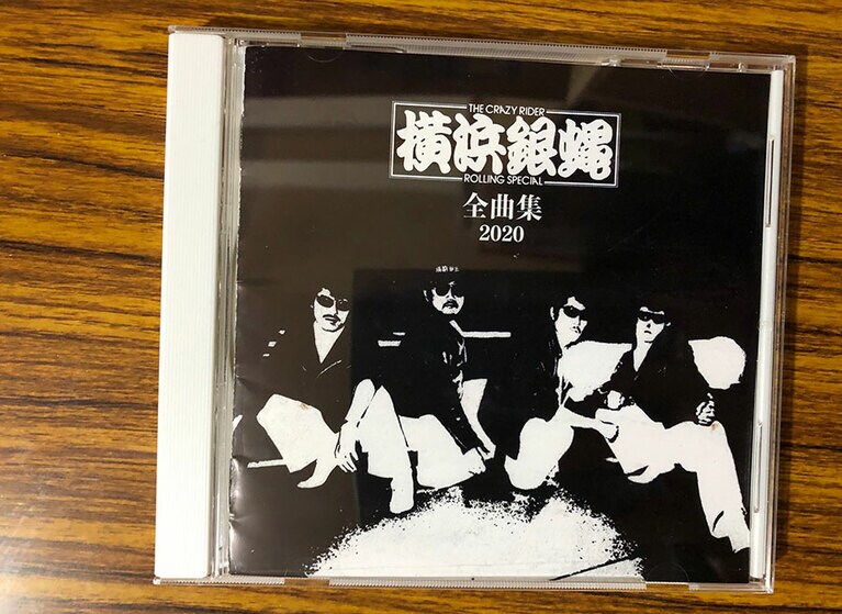「横浜銀蝿全曲集2020」。名曲揃いなのだがCDの撮影に困り果てた。ジャケットが黒くて、どうしても私が映り込んでしまう！　……いや、これも横浜銀蝿の愛。不器用なヤツは生きにくい。だからこそ踏ん張るのさと、さりげなく教えてくれているのだろう。