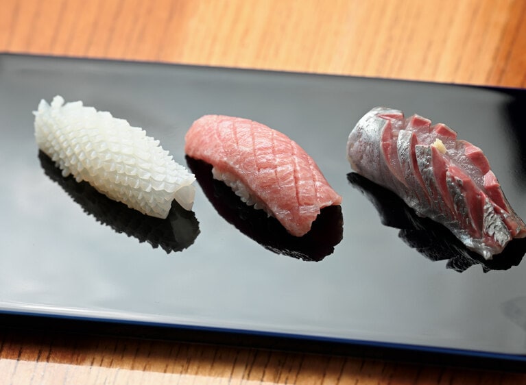 左から、見事な格子状にデザインされたアカイカ、マグロの中トロ、アジ。アートのように洗練された佇まいに食べるのが惜しくなります。イカは塩とスダチを絞り、ポン酢を数滴。ねっとりと濃厚な旨み。