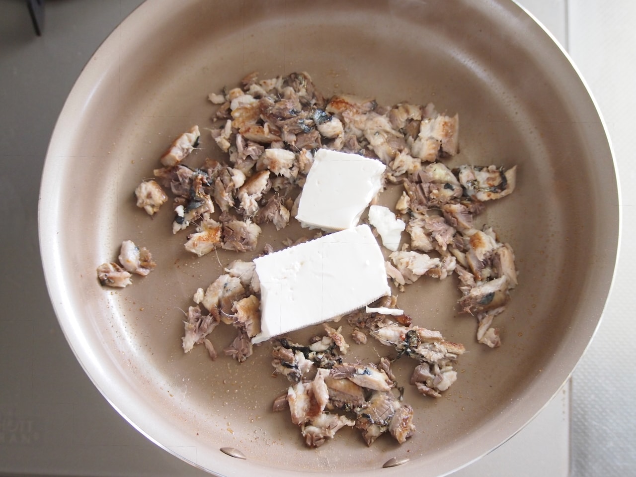 ヒレと尾を取り除いたら、木綿豆腐を加え、細かくそぼろ状になるまで炒める。