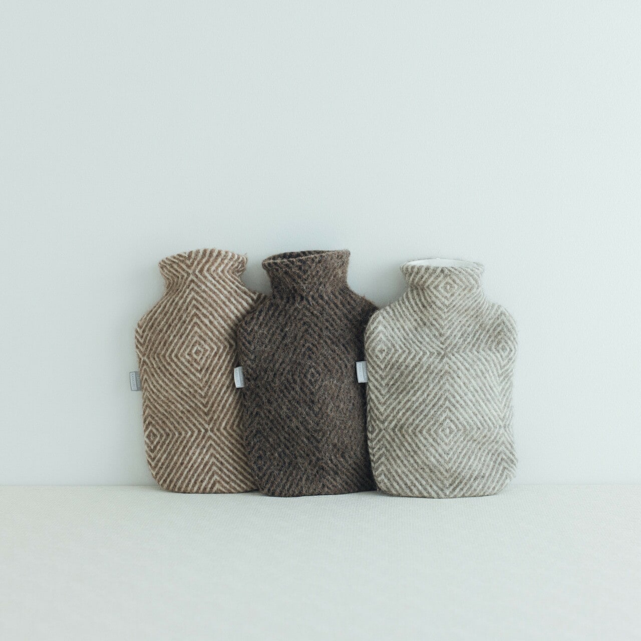 「MARIA 湯たんぽ」左から：ブラウンホワイト、ブラウンブラック、グレーホワイト 各約W21×D7×H32cm 9,680円／LAPUAN KANKURIT※POP-UPではブラウンブラック（中央）を販売。