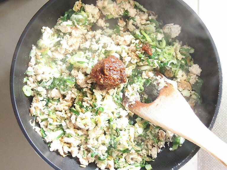 長ネギがしんなりしてきたら、はちみつ、味噌を入れてさらに炒める。