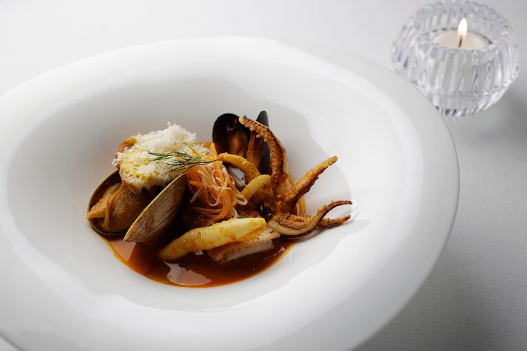 「Main Dining 白夜」のメニュー例「道南ブイヤベース」。フランスなどで研鑽を積んだ北海道出身の総料理長・因藤氏が“EZO食材”と向き合い、新たに創り出したひと皿。