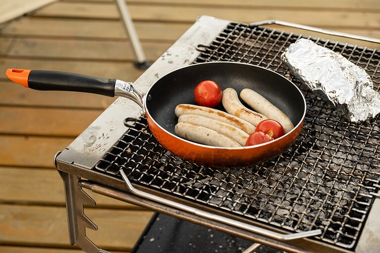 キャンプの楽しみである焚き火は調理にも活用。焦げ目をつけた焼きソーセージは、表面がパリッとして中身はやわらか。嚙みしめるたびに旨みが広がります。