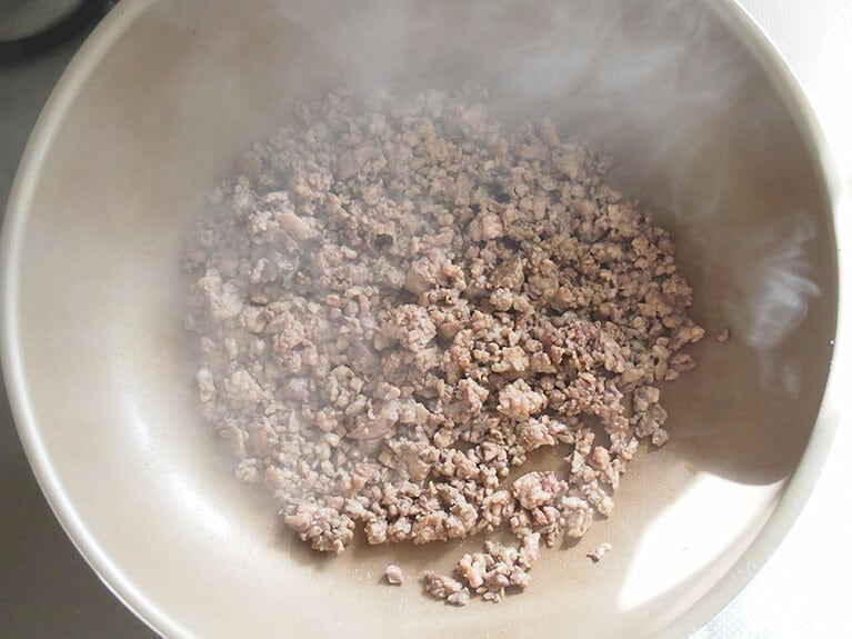 赤みがなくなるまで、木べらで細かく肉を崩すようにしながら炒める。