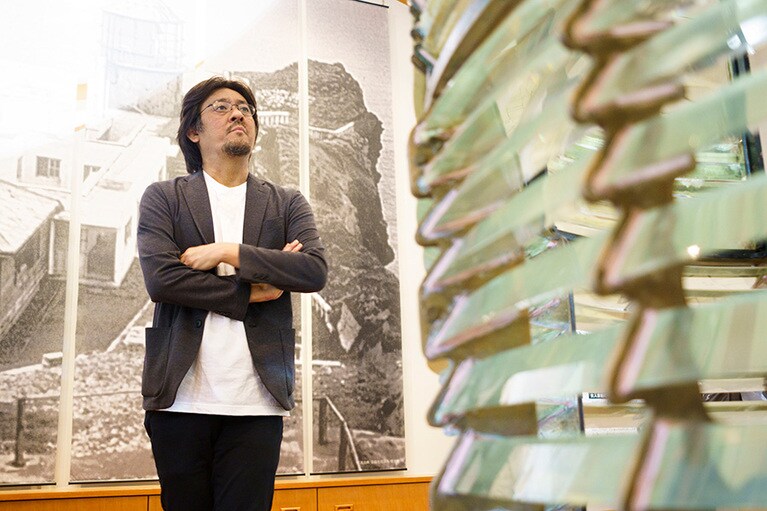 レンズを観察する川越さん。