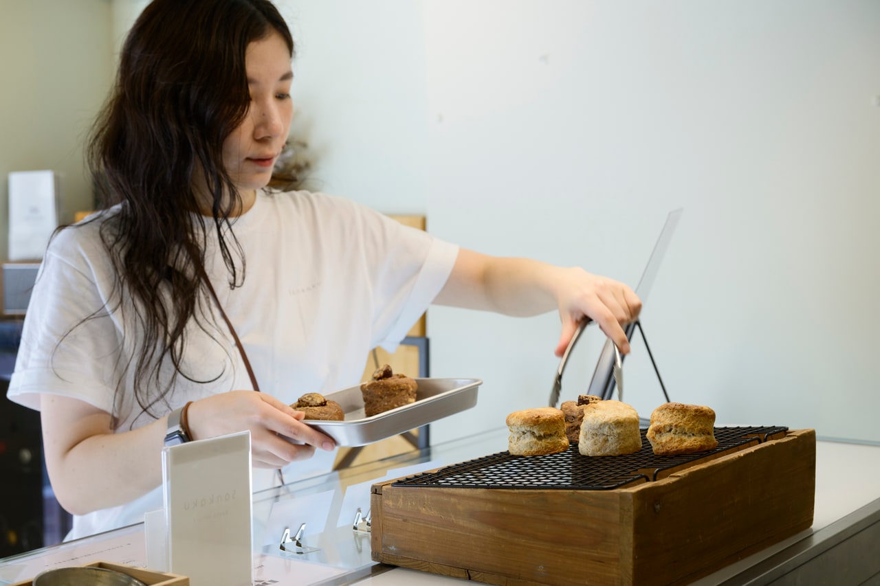 岡田さんの人柄と焼き菓子の味に惚れ込んだという、スタッフのmomoさん。お店のおすすめメニューは？「キャロットケーキはぜひ。スコーンはどれも美味しいけれど、私は結局プレーンに戻って......選べません！」
