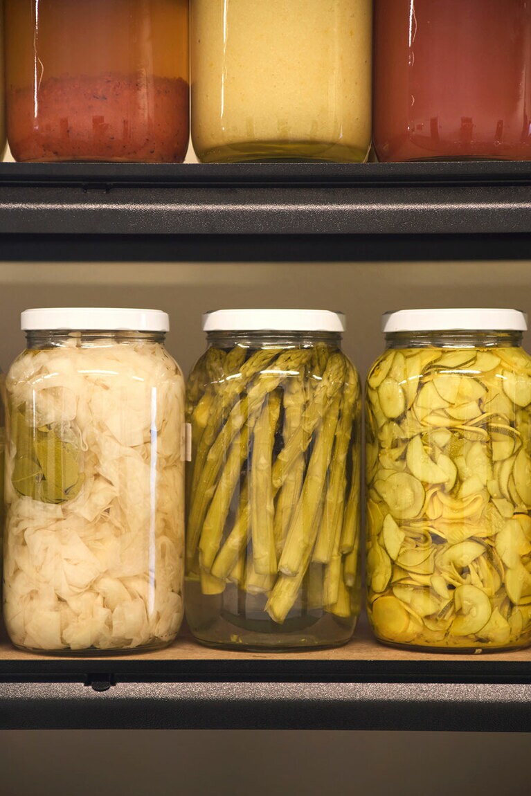 左：瓶で熟成された自家製のピクルスや調味料。
右：料理教室の前に、自家菜園で野菜を収穫する。ガイド役はオーナーのひとり、ロドニー・ダン氏。