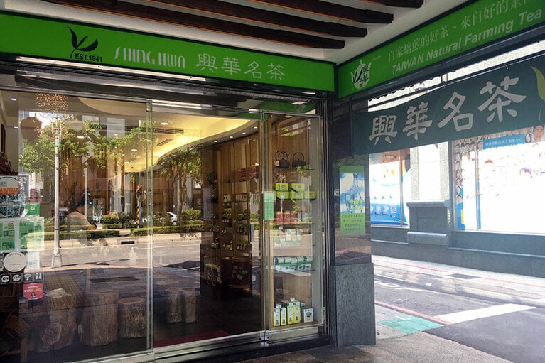 「興華名茶」の外観。建物の外壁も含めて全体がお茶カラーのグリーンでデザインされています。