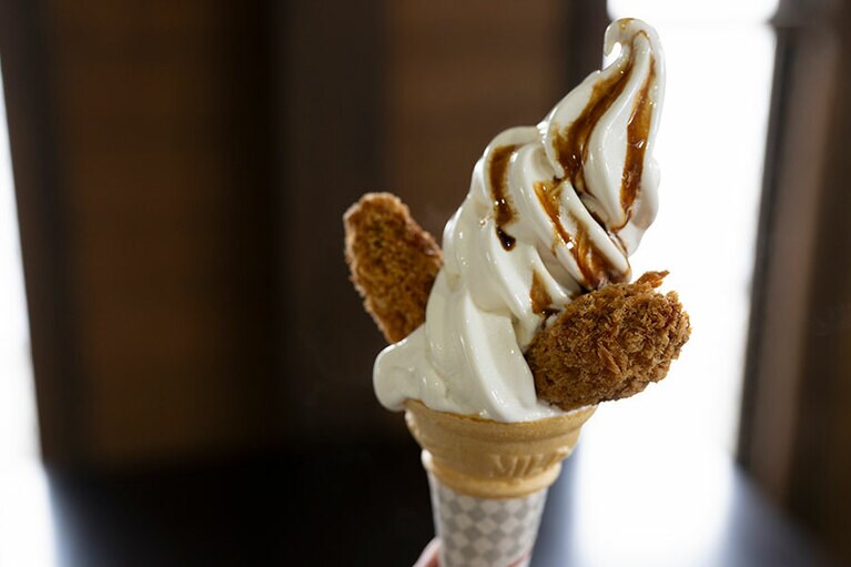 ソフトクリームにカキフライと甘みのあるたまり醬油がかかった「カキフライソフト」（300円）。日生駅から徒歩20分ほどにある、日生町漁協の魚市場「五味の市」で提供。