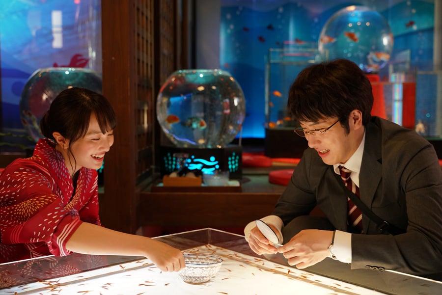 映画『すくってごらん』で、プライドは高いがネガティブな銀行員・香芝誠を演じる尾上松也(写真右)と、彼が一目ぼれする美女・吉乃を演じる百田夏菜子(写真左)。