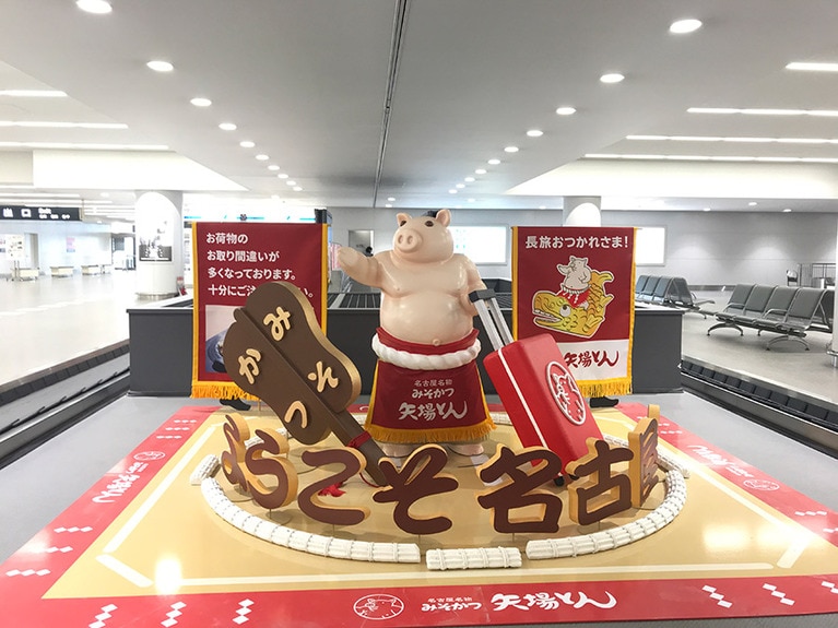 手荷物受取所のターンテーブルでは「ようこそ名古屋へ」と、横綱の姿をした豚が迎えてくれた。