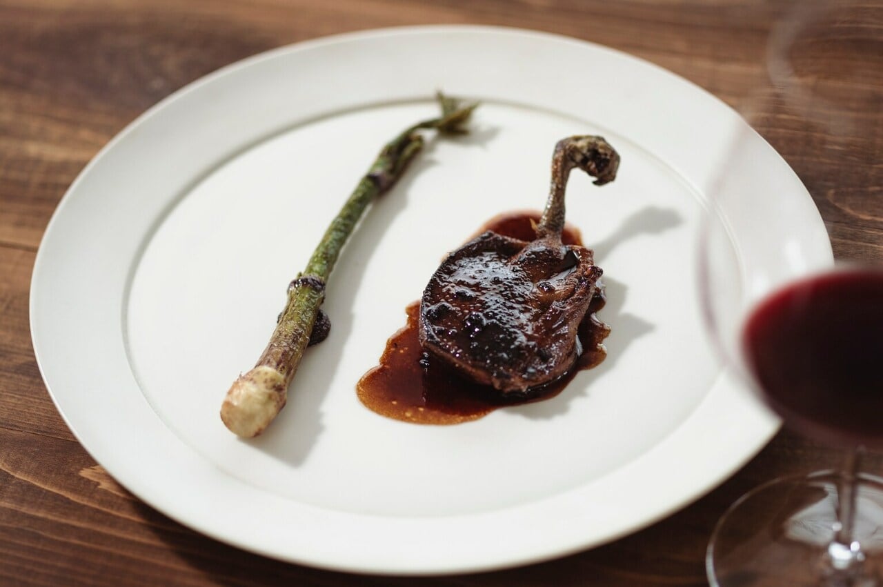 秋に収穫した天然のコウタケと鴨出汁のソースといただく「小鴨のロースト」。山うどのバターソテーを添えて。