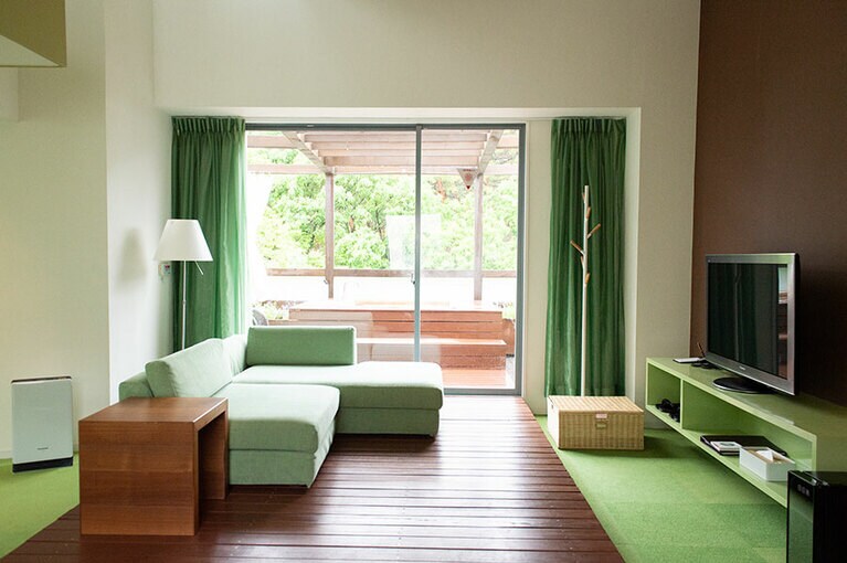 爽やかなグリーンカラーのインテリアと暖かな木目が調和するメゾネットタイプのスイートルーム。テラスには、爽やかな風を感じる露天風呂も。