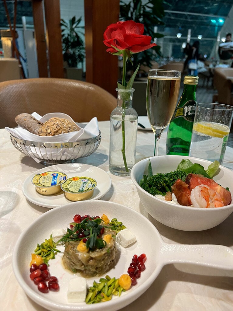 手前は中東料理の定番、焼いたナスをペースト状にしたサラダ、フェッタチーズ、ザクロ、ピスタチオ添え。シャンパンは「モエ・エ・シャンドン」だ。