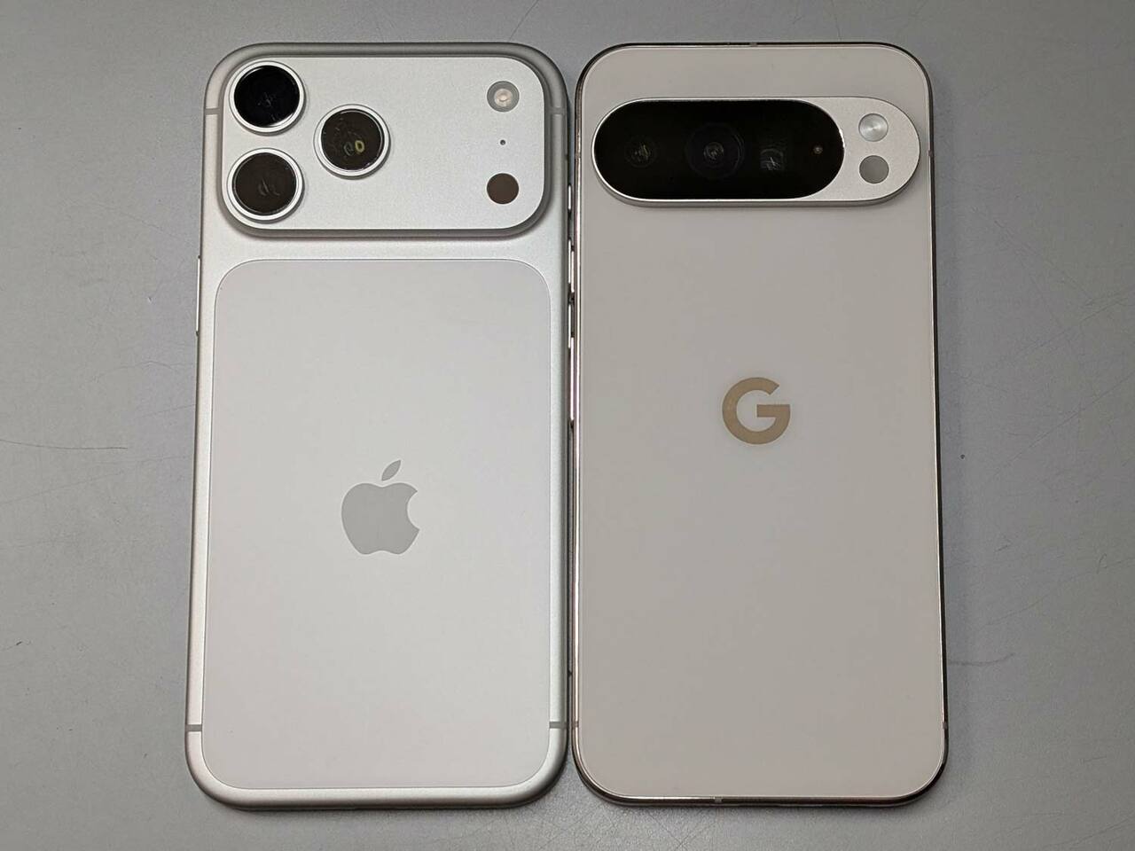 背面。カメラ部は、iPhone（左）のデザインが従来とはがらりと変わり、Google Pixel（右）と同じく横一列を占めるサイズへと大型化しているほか、背面パネルが周囲フレームと異なる素材に改められています