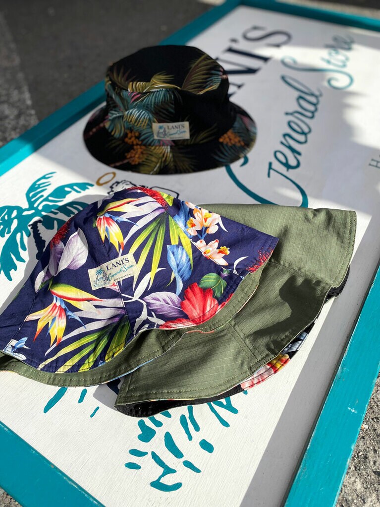 リバーシブルのチューリップハット 40ドル(手前)、アロハ柄のバケットハット 45ドル(奥)。