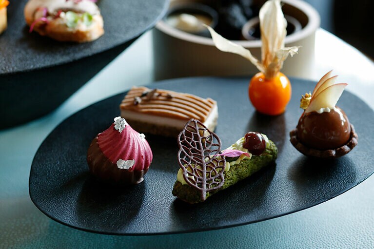 ほおずき アプリコットとヴァニラのパート ド フリュイ／カシスのムース／ピスタチオのエクレア／タルト ポム／栗 グリュエ ド カカオの糖衣がけ／洋梨のジュレ。