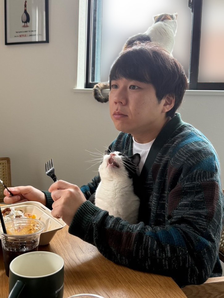 秋山さんと愛猫のキキちゃん（三毛）、ググちゃん（白黒）。