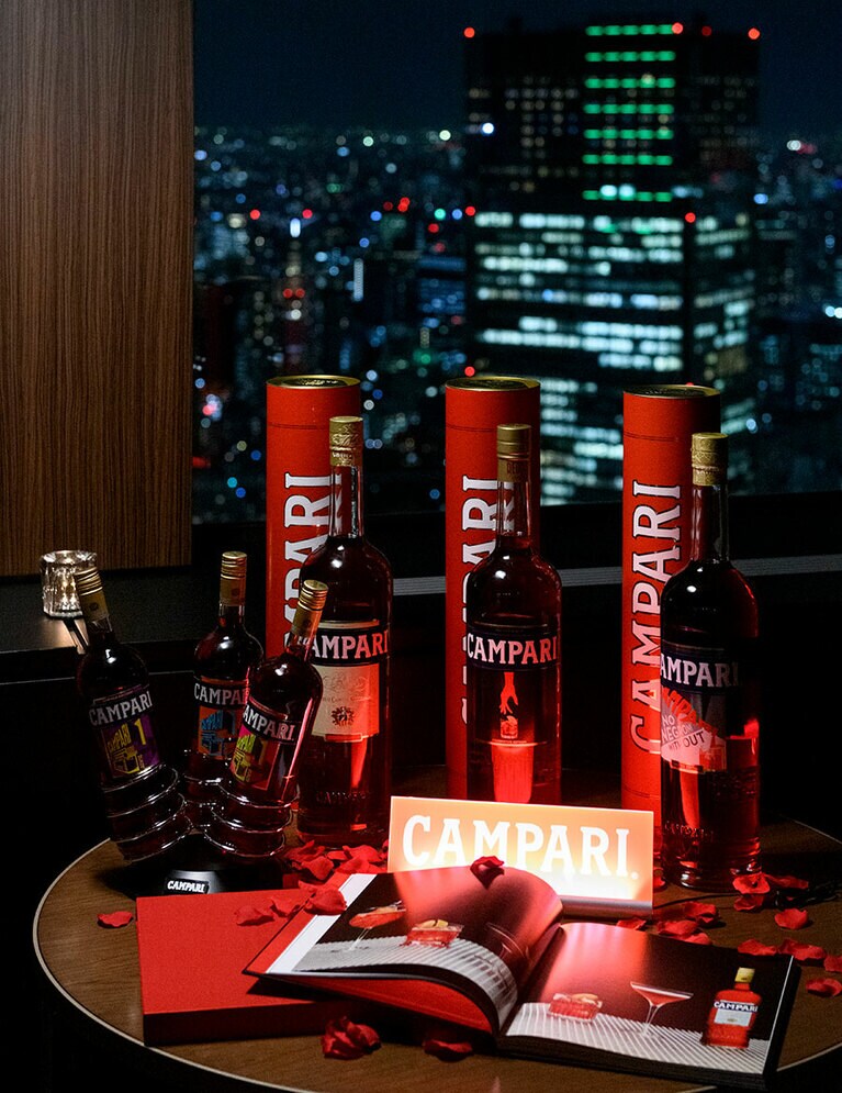 東京の夜景をバックに輝くカンパリ。ラベルを彩る「カンパリ＝アート」にも注目。カンパリ1,000ml 1,960円、750ml 1,550円、375ml 870円(すべて税別)。