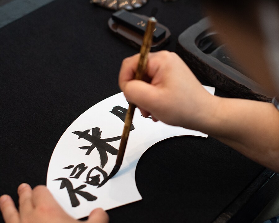 県の伝統工芸である赤間硯で墨をすり、扇子型の和紙に絵や文字を綴るご当地楽「大人の墨あそび」(当日予約)。