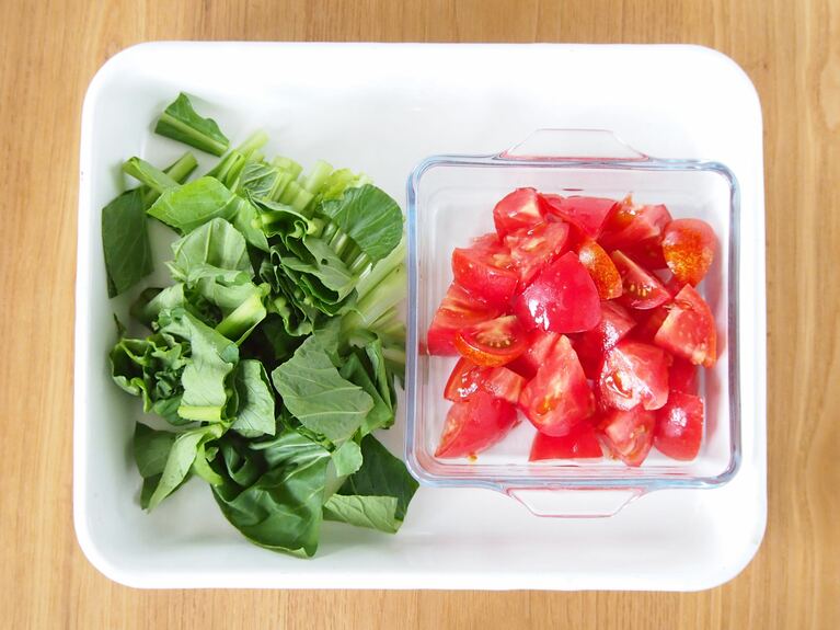 小松菜は株を切り落とし、4cmの長さに切る。トマトはヘタを取り除き、角切りにする。