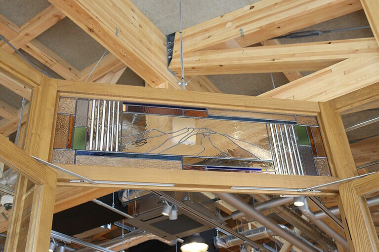 入口にあるステンドグラスのモチーフは、軽井沢の北に雄大にそびえる浅間山と、長野県のシンボルである白樺。パタゴニアロゴのカラーリングになっている。