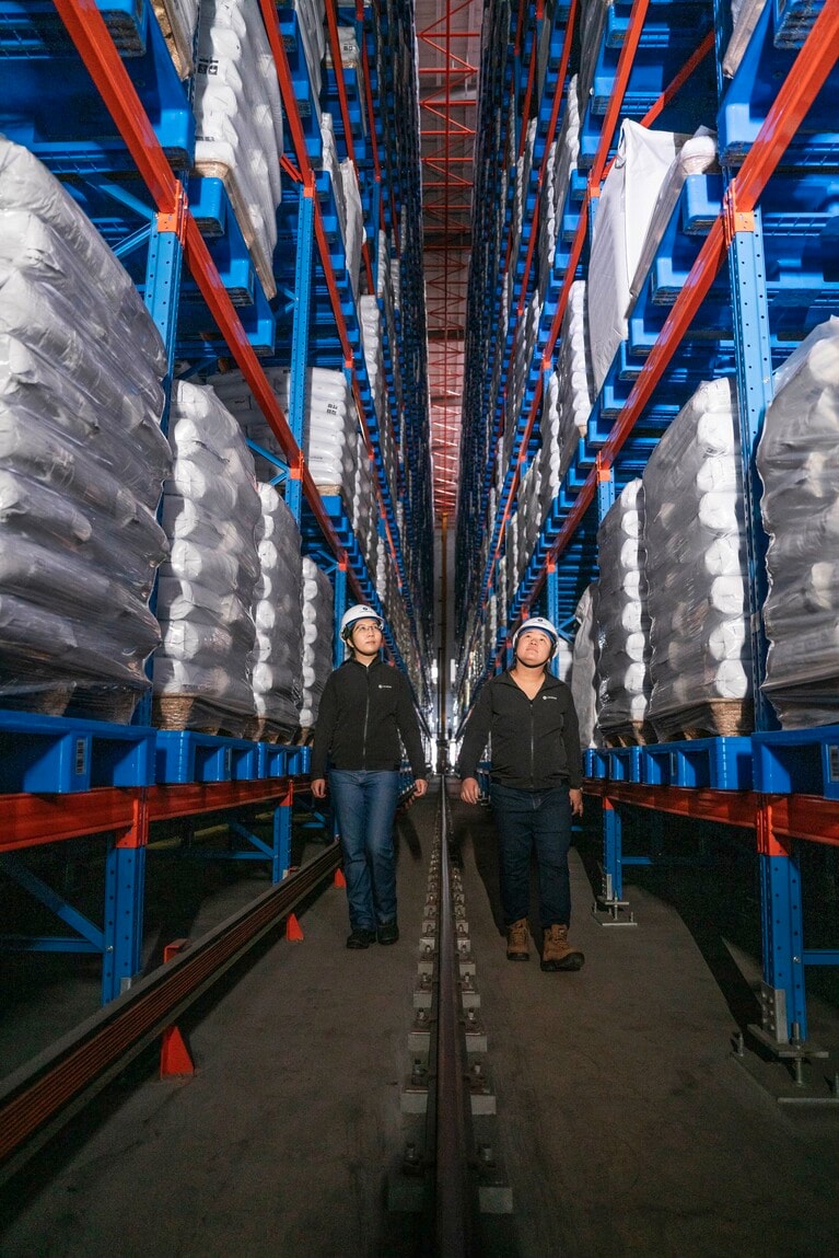 中国の提携企業の最先端施設でポリウレタンが積まれた倉庫を歩くミランダとヤオ。© Rolex/Roman Meisenberg