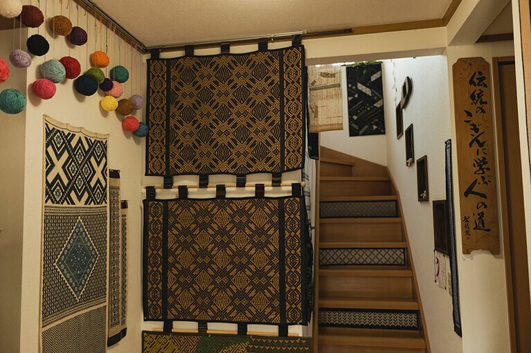 階段の横に飾られている作品は上が表で下は本来はこぎんの裏側だったものを改めて佐藤さんが製図して表に仕立てたもの。表と裏で表情が異なるのもこぎんの魅力だ。