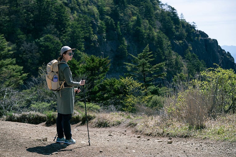 金子さんの奥に見えるのが、垂直の岩壁がそびえる屏風岩。