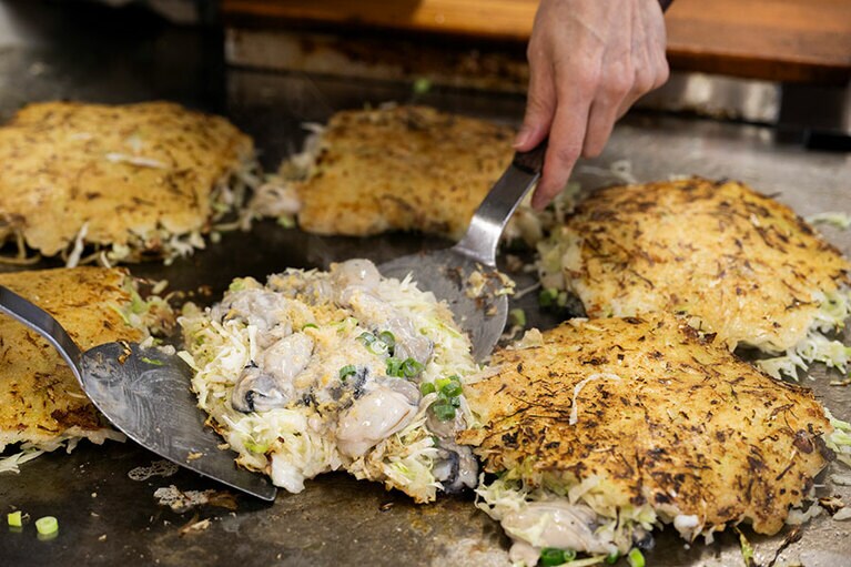トロトロの生地はカリっと香ばしく焼き、カキはふっくらジューシー。「お好み焼オレンジハウス」ではカキ増量のカキオコ（1,400円）も提供。