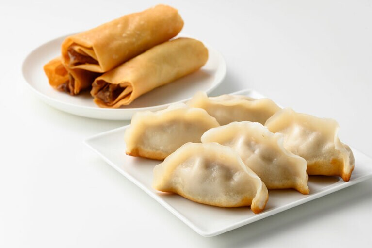 手前から：焼きギョーザ173円(1個)、春巻き195円(1本)。