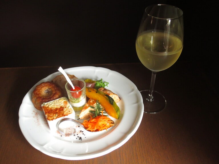 「ブランチプレート」1,210円。グラスワイン（白）770円。取材時は、ピエモンテ風ポテトサラダ、自家菜園のニンジンを使ったキャロットラペ、カボチャのローストにローズマリーと蜂蜜を添えて、フリッタータ（イタリア風オムレツ）、ハモンセラーノ、カリフラワーのピクルス、カプレーゼ、自家製パン。