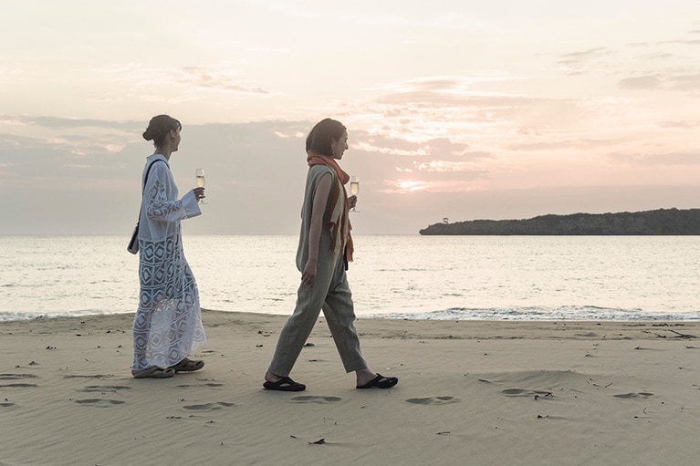 【サンダル以外の衣装】モデル左：サコッシュ［ハーベスト マテリアル モジュラー トラベル ポーチ Fawn/Birch］3,520円／キーン(キーン・ジャパン)、その他／スタイリスト私物。
右：サコッシュ［ハーベスト マテリアル モジュラー トラベル ポーチ White/Black］3,520円／キーン(キーン・ジャパン)、ジャンプスーツ 50,600円／シー（エスストア 03-6432-2358）、その他／スタイリスト私物。