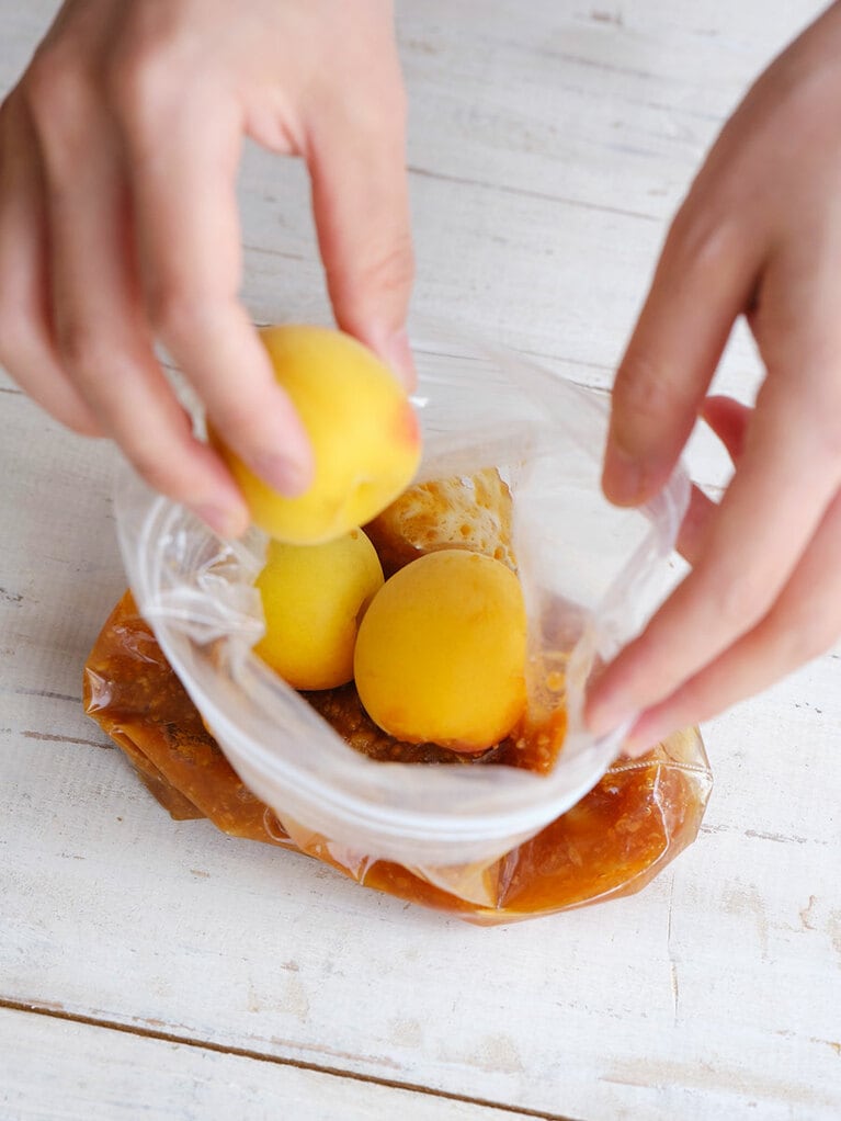 （4）梅を加えて、空気が抜けるようにジッパーの端を少しあけて口を閉じる。