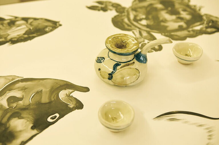 【丹羽優太「勸酒精 -酒精を勧める-」】災害などを、鯰や大山椒魚といったモチーフで表現する丹羽氏。今回はそれらが大胆に描かれた和紙の上に、清水焼の窯で制作した作品をあしらったユニークな展示方法を採用。