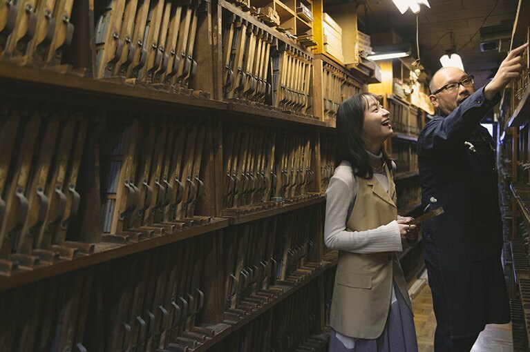 金属活字の説明をする佐々木さんと影山さん。