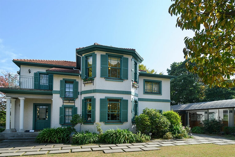 白壁に緑の窓枠と赤い屋根が美しい「ブラフ18番館」［横浜市認定歴史的建造物］。