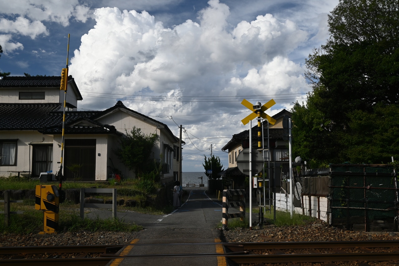 踏切の先、住宅の間に雨晴海岸が。