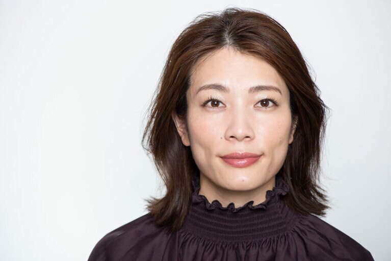 ツヤと彩りを効かせたメイクで、シンプルな眼鏡でも華やかな印象に。メタル素材の質感と品良く調和しています。