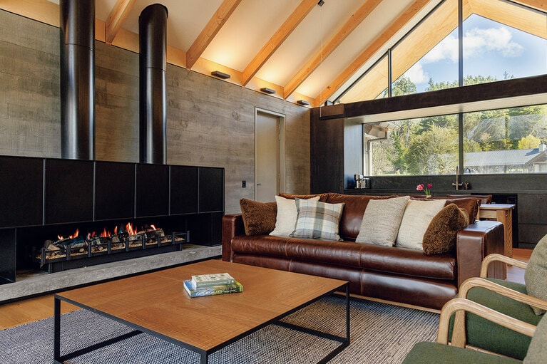 モダンなデザインのストーブが配された広々としたヴィラのリビング。©Lisa Sun Photography