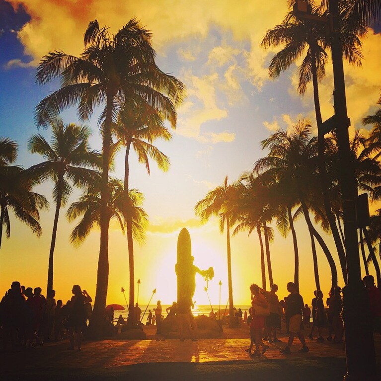 冬ならワイキキのシンボル「デューク・カハナモク像」越しに水平線に沈むサンセットが！