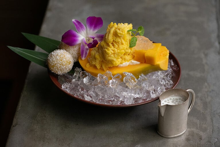 「マンゴーココナッツ団子とマンゴーかき氷のパパイヤ器仕立て」3,850円（サービス料15％別）。デザートとしてのみ注文可能。