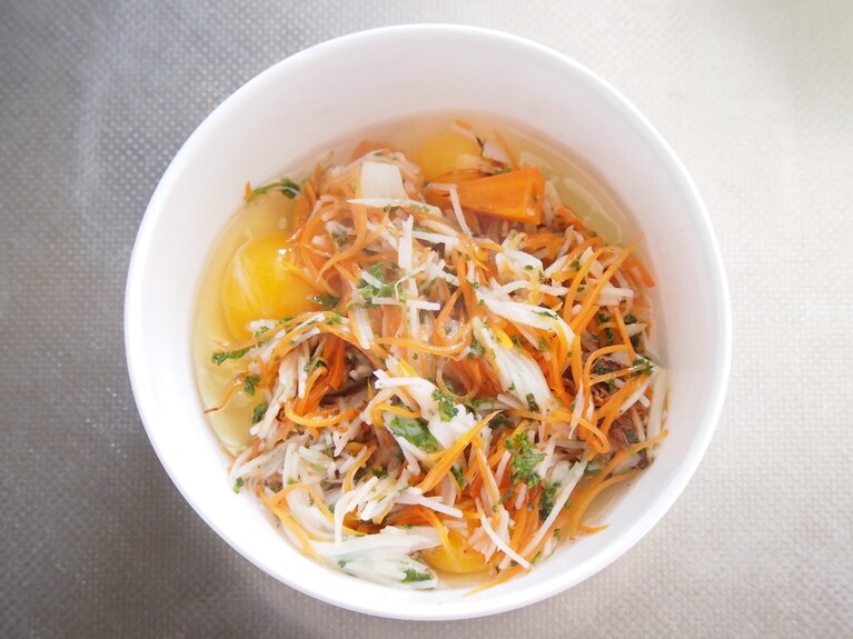 野菜がしんなりしたらボウルに取りだし、卵を割り入れ、塩を加えてよく混ぜる。