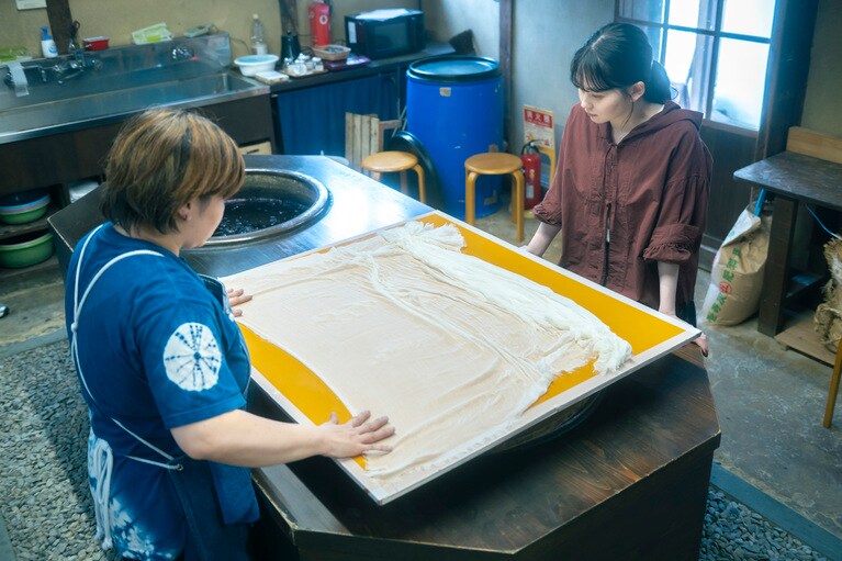 まっさらなシルクの布地と対峙する山田さん。天然素材ならではの風合いも魅力的。