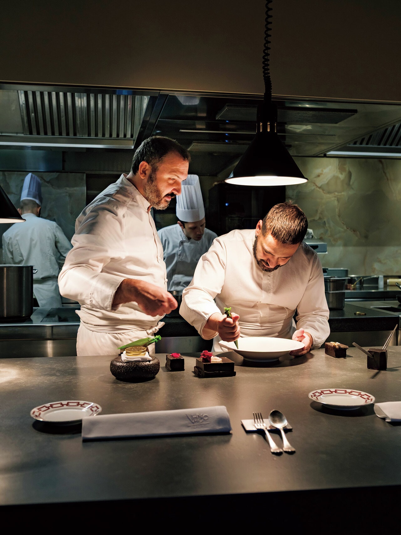 プーリア出身の兄レモ（左）と弟マリオ（右）。寡黙な兄と明朗快活な弟は正反対だが、息の合った動きで美しく盛り付けられゆく皿に期待が高まる。