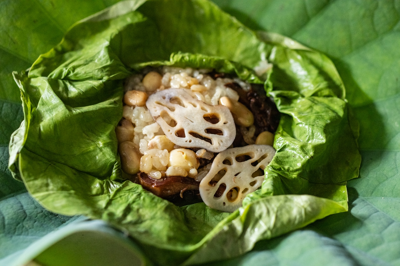 蓮の葉を広げると、ふわっとなんともいい香り。ベースの味付けはしょうゆおこわで、蓮根、蓮の実、夏キノコと具沢山。ノンアルドリンクのときは蓮の花の茶を出しているそう。